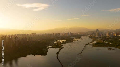 Stunning sunset aerial view of Jinghong and the Lancang River in Xishuangbanna, showcasing nature's beauty and cityscape harmony
