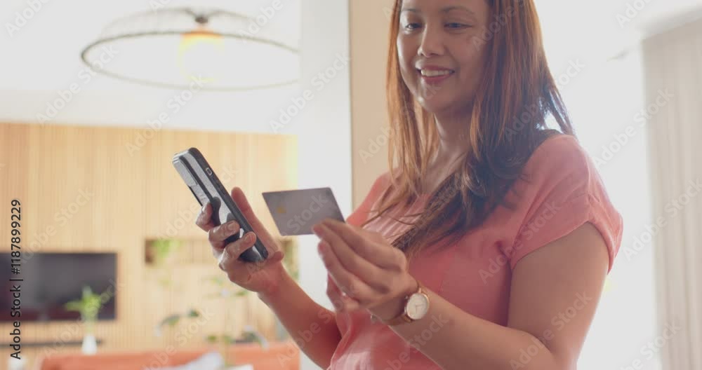 Holding credit card and smartphone, woman smiling and making online payment Holding credit card and smartphone, woman smiling and making online payment