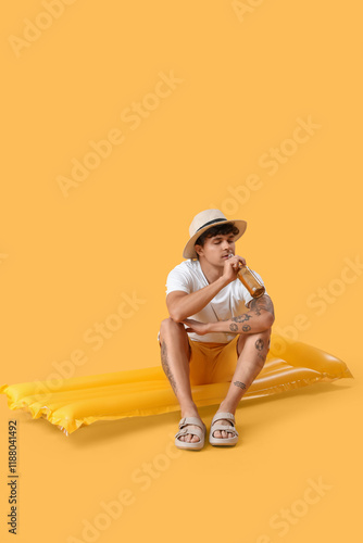Young man with beer and swi...