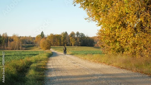 A cycling tourist riding on a country road in autumn
