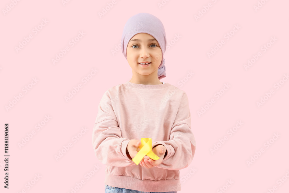 Little girl after chemotherapy with yellow ribbon on pink background. Childhood cancer awareness concept Little girl after chemotherapy with yellow ribbon on pink background. Childhood cancer awareness concept