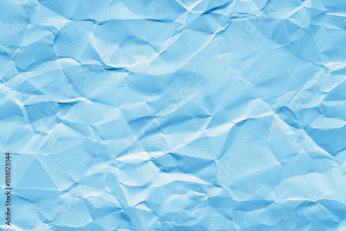 Creased or crumpled blue colored paper background. Wrinkled blank sheet texture with grain or noise