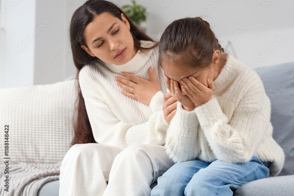 Mother apologizing to her crying daughter on sofa at home Mother apologizing to her crying daughter on sofa at home