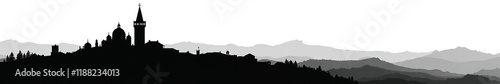 Silhouette of a historic building against a mountainous landscape at dusk.