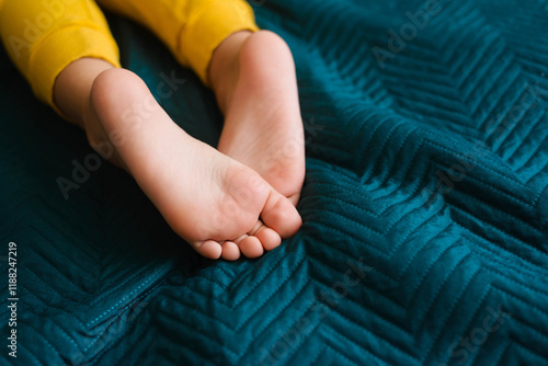 Children's feet and heels on a dark blue bed. Importance of sleep for babies. Sleep mode babies 5 y.o photo