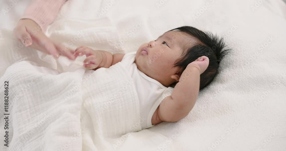 Mother gently wiping newborn baby’s mouth with cloth on soft white blanket. Represents warmth, cleanliness, care, and the nurturing connection between mother and child during early caregiving. Mother gently wiping newborn baby’s mouth with cloth on soft white blanket. Represents warmth, cleanliness, care, and the nurturing connection between mother and child during early caregiving.