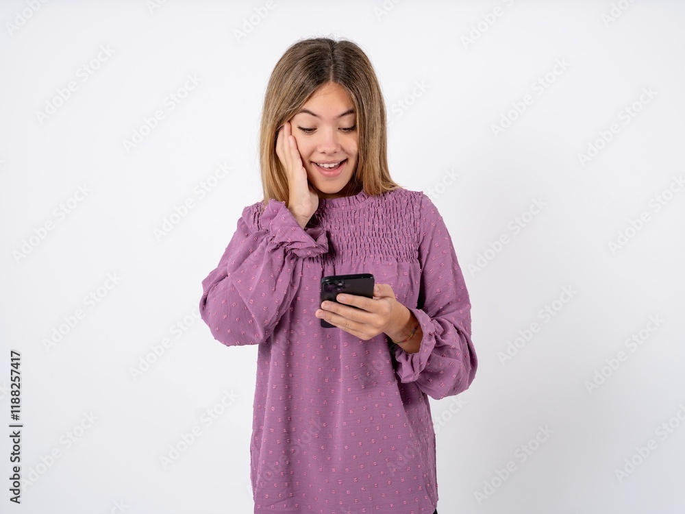 Beutiful caucasian gteen girl wearing pink T-shirt holding in hands cell reading sms using new app 5g Beutiful caucasian gteen girl wearing pink T-shirt holding in hands cell reading sms using new app 5g