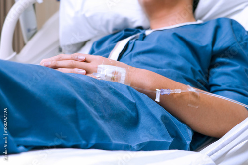The saline tube on the left hand of the patient is giving the saline solution that lies in the hospital bed