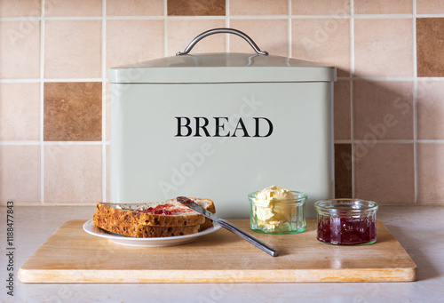 Making a Jam Sandwich on a bread board showing slices of bread jam and butter