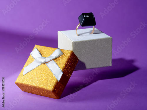 Close-up of a computer esc key on a gold ring in a ring box