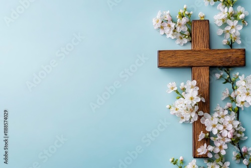 Wooden cross with spring flowers on blue background with copy space. Religion background. Religious church holidays. Christianity Feast, Easter, Palm Sunday, Christening, church wedding. Flat lay 