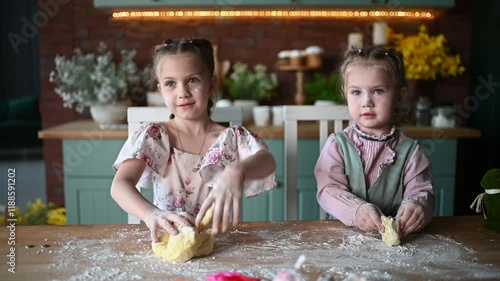 Playful sisters making dough and enjoying their time in the kitchen