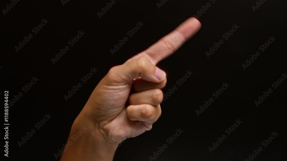 Man pointing with index finger against black background, hand gesture close-up showing direction, communication in dark setting Man pointing with index finger against black background, hand gesture close-up showing direction, communication in dark setting