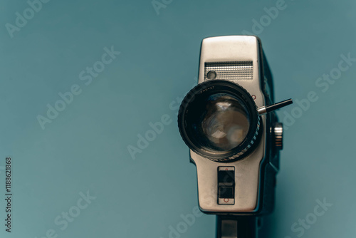 A classic film camera positioned against a blue backdrop photo