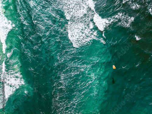 Aerial view of kitesurfer riding on waves at Baltic Sea.