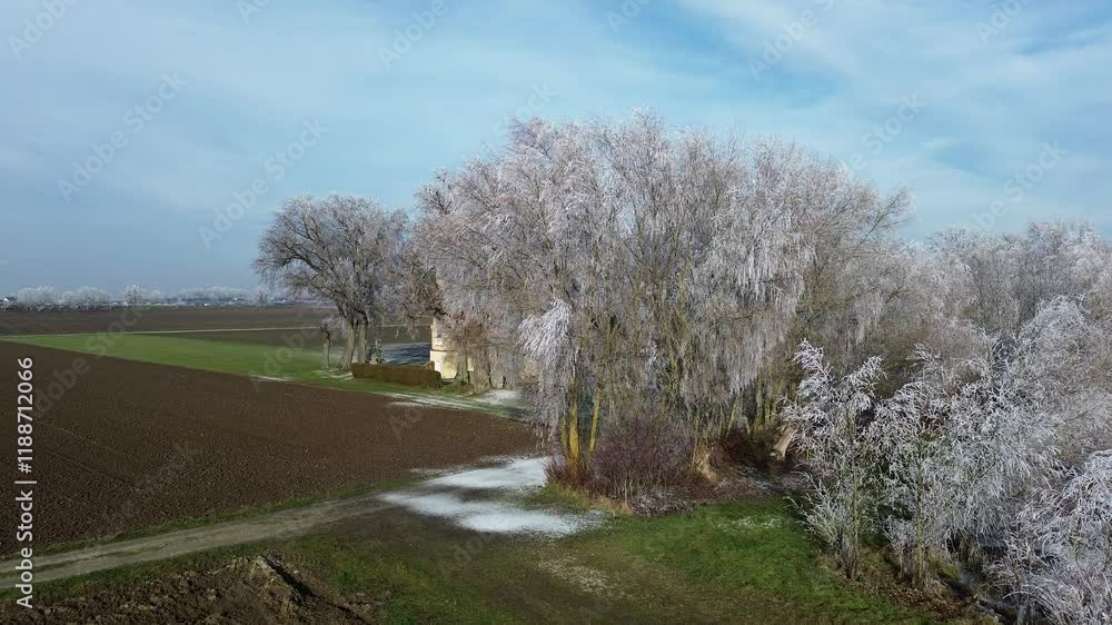 Drone winter view with frozen trees and a pond captured in flight near Sebastianikirchlein Wallersdorf, Dingolfing-Landau, Bavaria, Germany Drone winter view with frozen trees and a pond captured in flight near Sebastianikirchlein Wallersdorf, Dingolfing-Landau, Bavaria, Germany
