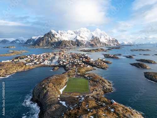 Aerial shot of a soccer field on an island with mountains in the background, winter time in Norway