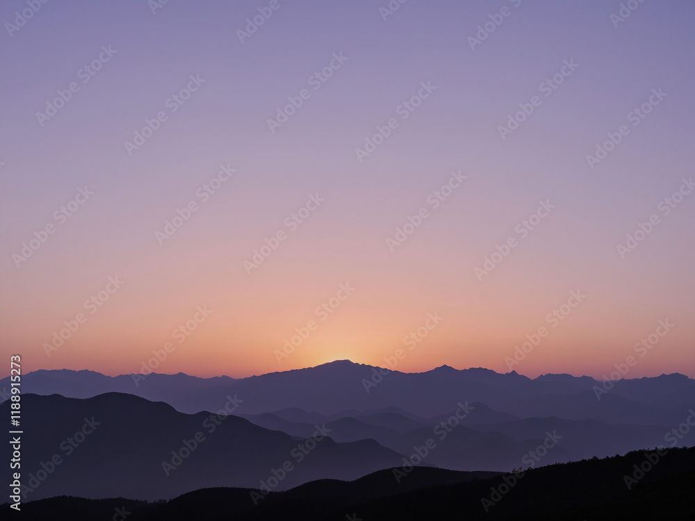 Obraz premium a serene and minimalistic sunset over a silhouette of distant mountains.