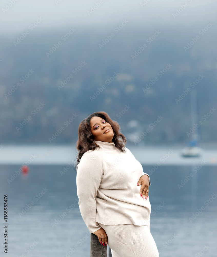 Confident african female in white outfit by tranquil lakeside Confident african female in white outfit by tranquil lakeside