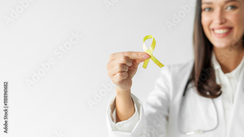 Woman doctor holding yellow ribbon symbol of Sarcoma Bone cancer, Bladder health, Liver disease, Spina Bifida Awareness and Childhood caner photo