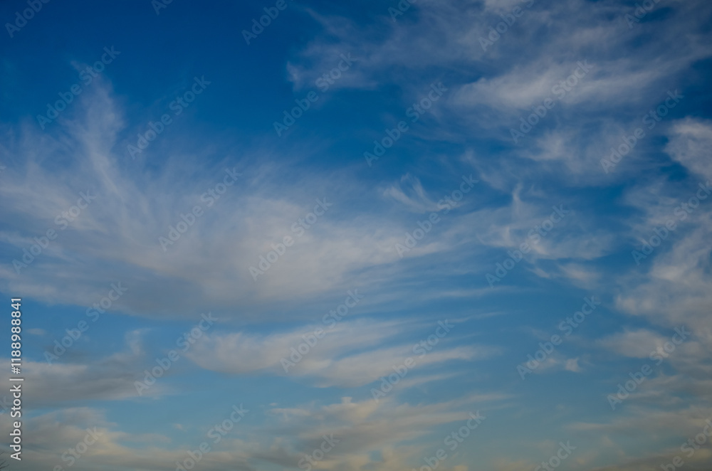 Striking cloud patterns gracefully drift across the deep blue sky at sunset Striking cloud patterns gracefully drift across the deep blue sky at sunset