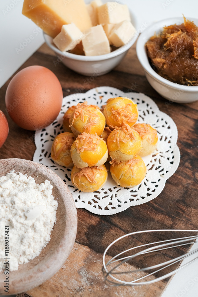 Kue nastar or pineapple tart. indonesian eid snack (kue lebaran). on a wooden plate with ingredients. bright mood style. perfect for recipe, article, catalogue, or any commercial purposes.