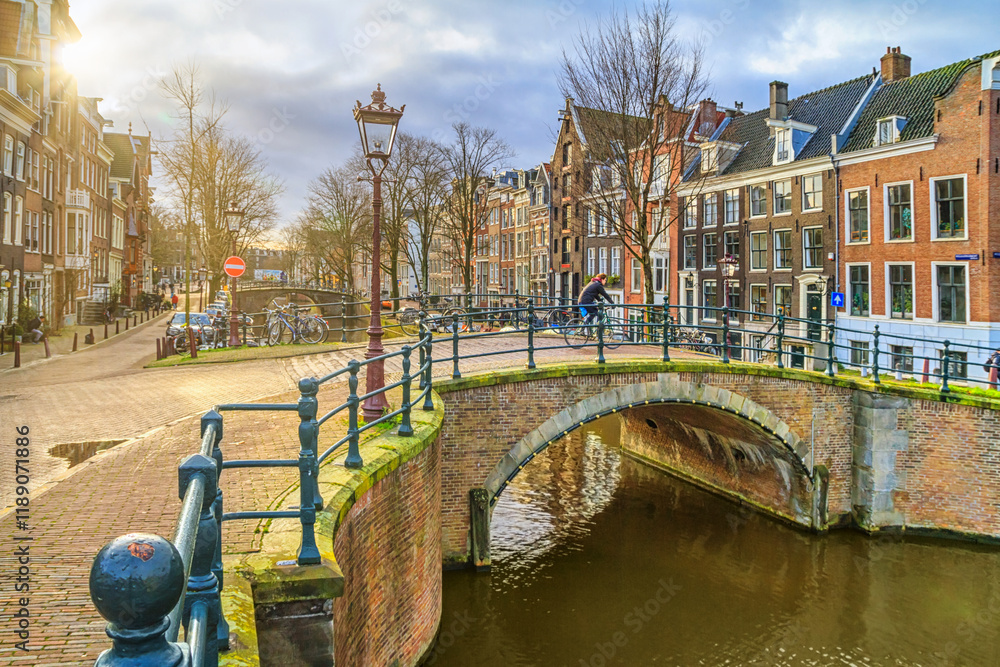 Cityscape on a sunny winter day - view of the bridge and canal in the historic center of Amsterdam, The Netherlands