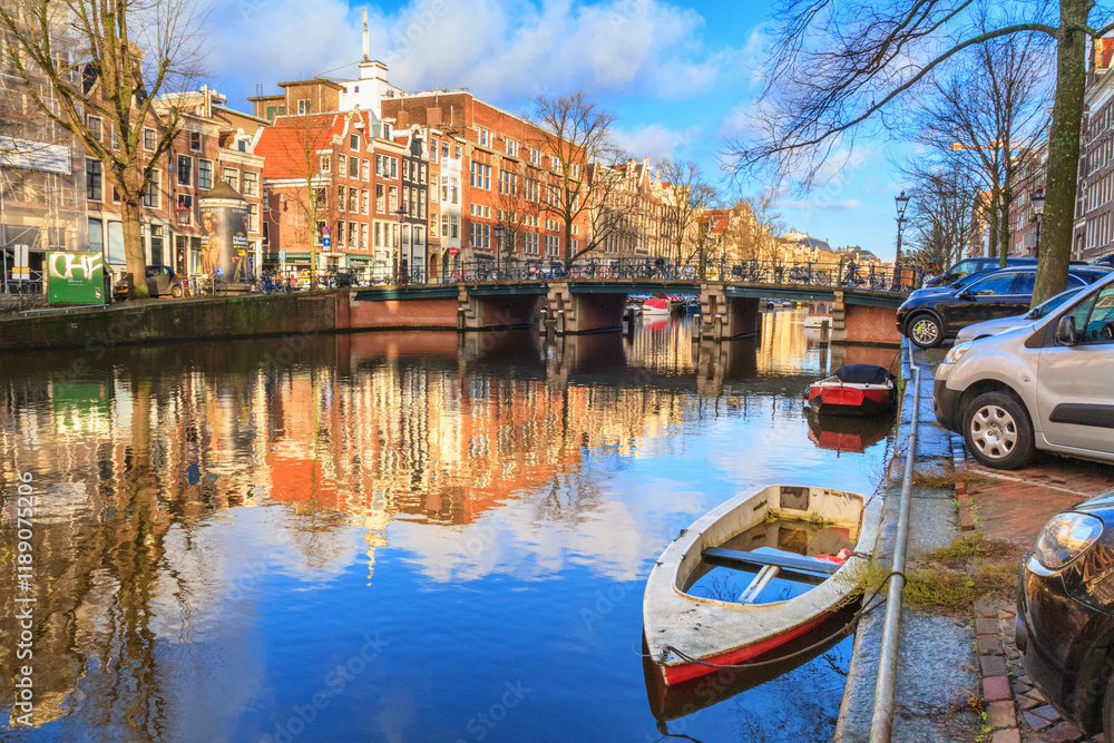 Cityscape on a sunny winter day - view of the canal and bridge in the historic center of Amsterdam, The Netherlands