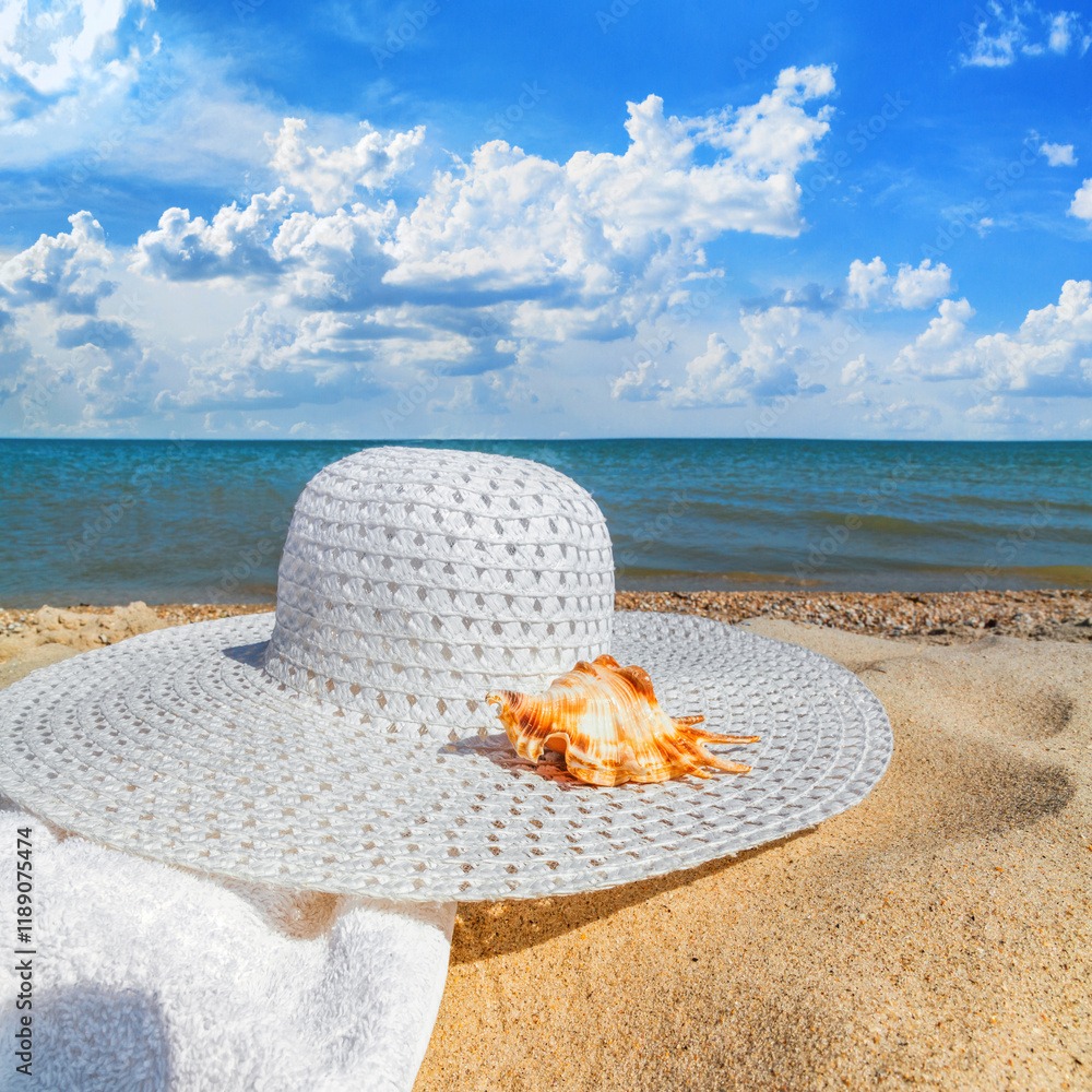 Close-up view of a sun hat on a sandy beach by the sea, selective focus. Beach holiday concept, background with copy space for text