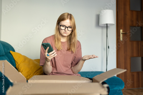 Unhappy young blonde woman frustrated by wrong order shopping online using smartphone. Upset female buyer unbox parcel buying on web confused with bad delivery service. Shipping concept