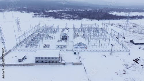 Aerial view of power substation enveloped in ice and snow during winter season