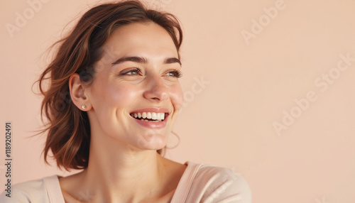 Smiling woman with short hair against peach background