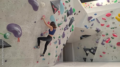 Female Rock Climber Tackling an Indoor Climbing Route