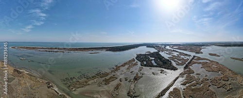 Aerial view of the Po Delta Nature Reserve with winding waterways, marshes, and islands blending into the Adriatic Sea under a bright, clear sky. photo