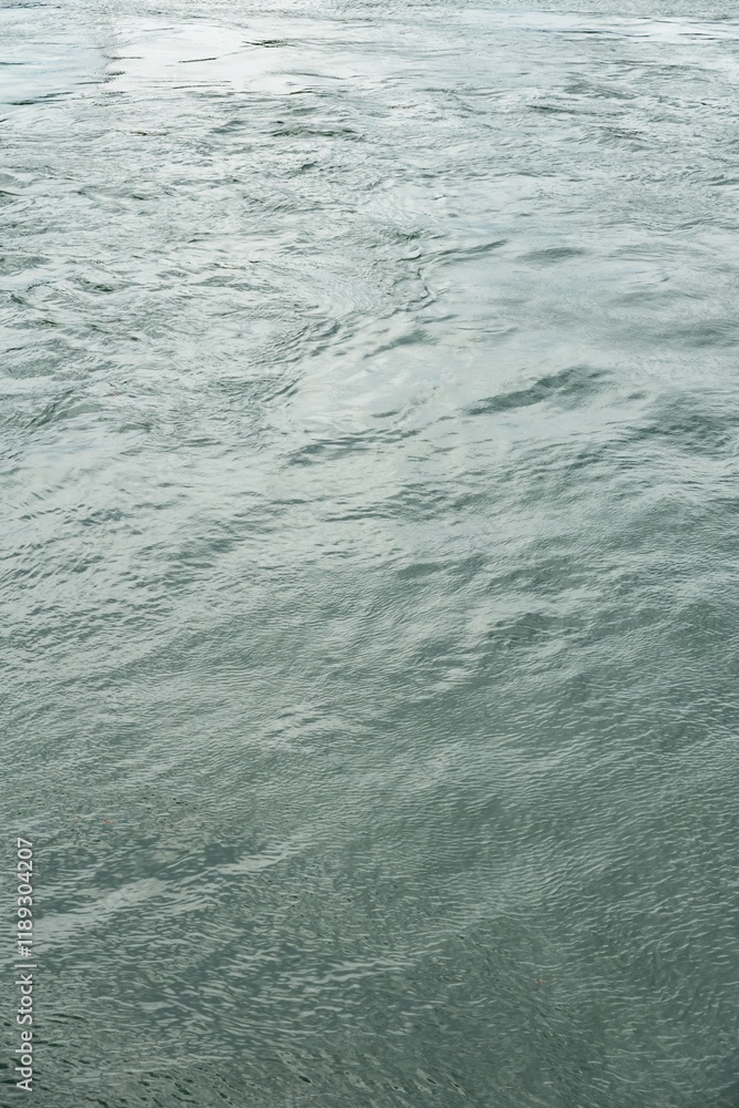 Abstract azure water surface with mild waves, vertical
