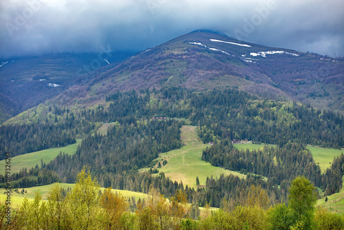 Obraz na płótnie Majestic mountain landscape showcasing lush greenery and distant peaks under a cloudy sky w salonie