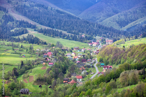 Obraz na płótnie Peaceful village nestled among lush green mountains during a bright spring day w salonie