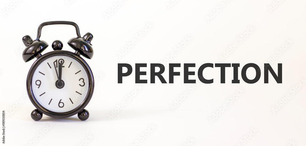 Perfection symbol. Concept word Perfection on beautiful white paper. Beautiful white paper background. Black alarm clock. Business perfection concept. Copy space. Perfection symbol. Concept word Perfection on beautiful white paper. Beautiful white paper background. Black alarm clock. Business perfection concept. Copy space.