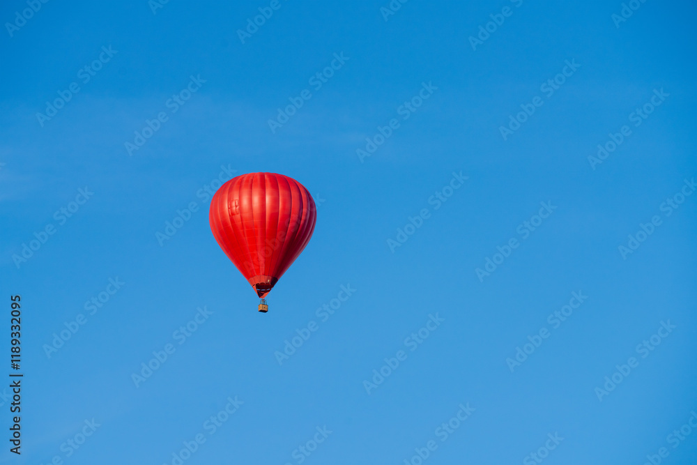 Flying red hot air balloon in the blue sky Flying red hot air balloon in the blue sky
