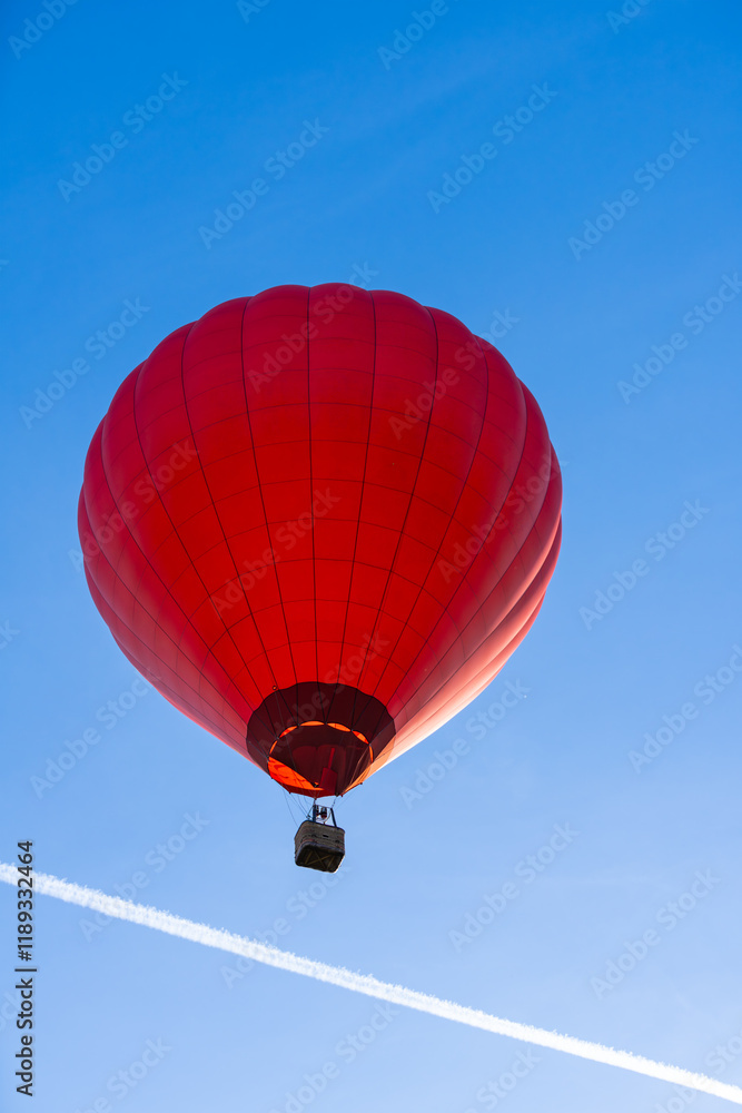 Naklejka premium Flying red hot air balloon in the blue sky