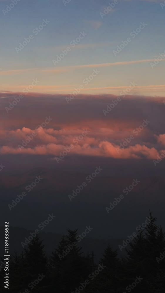 Vertical screen Sunset Over Smoky Mountains, USA picturesque view of Smoky Mountains, USA, during sunset, with layers of clouds glowing soft pink orange hues against peaceful horizon. Vertical screen Sunset Over Smoky Mountains, USA picturesque view of Smoky Mountains, USA, during sunset, with layers of clouds glowing soft pink orange hues against peaceful horizon.