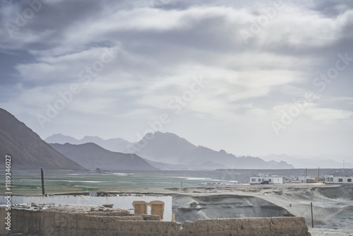 Minimalist silhouette of a mountain range in the highlands of the Tien Shan in the Pamirs in Tajikistan, panoramic landscape for the background with rocky mountains and the city of Murghab photo