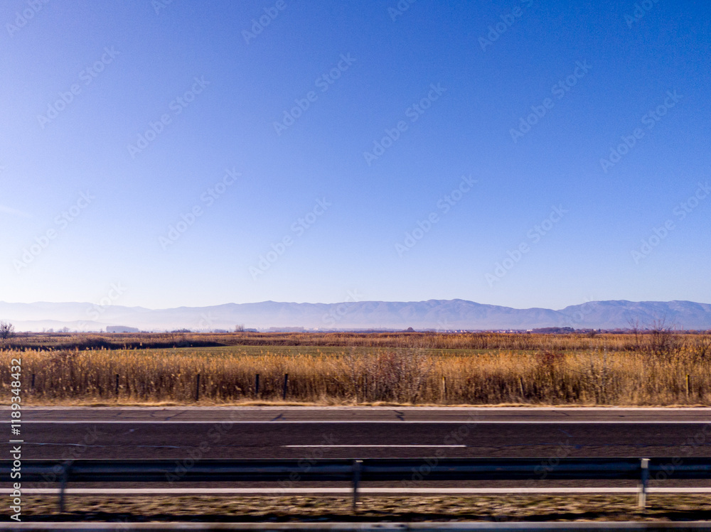 View to field and mountain from highway