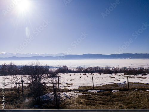 Obraz na płótnie View to field and mountain with fog and snow from highway w salonie