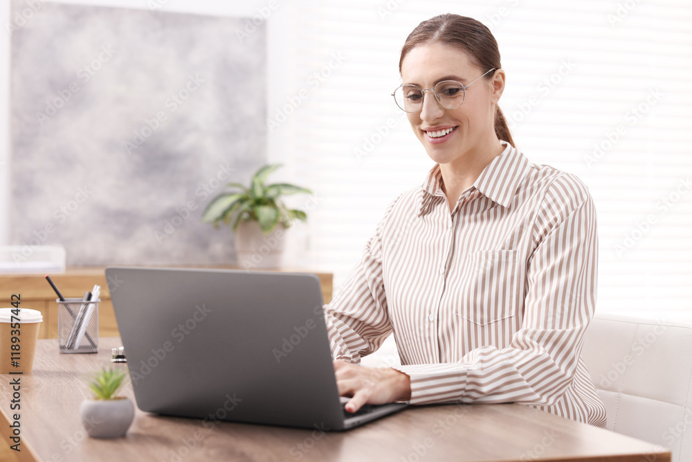 Programmer working on laptop at wooden desk indoors Programmer working on laptop at wooden desk indoors