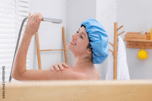 Woman with cap taking shower in bathroom photo