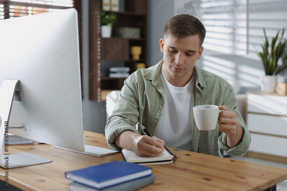 Handsome man working with computer at desk indoors. Home office Handsome man working with computer at desk indoors. Home office