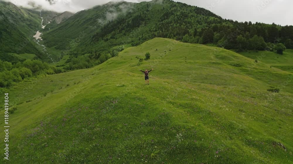 Solo traveler backpacker hiking alpine meadow. Enjoy views, freedom. Aerial selfie, rich green mountains, serene landscape, clouds. Hiking adventure, nature exploration. Traveling alone. Drone shot Solo traveler backpacker hiking alpine meadow. Enjoy views, freedom. Aerial selfie, rich green mountains, serene landscape, clouds. Hiking adventure, nature exploration. Traveling alone. Drone shot