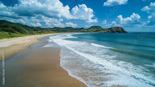 Coastal view of a serene beach with clear turquoise waters and lush green hil...