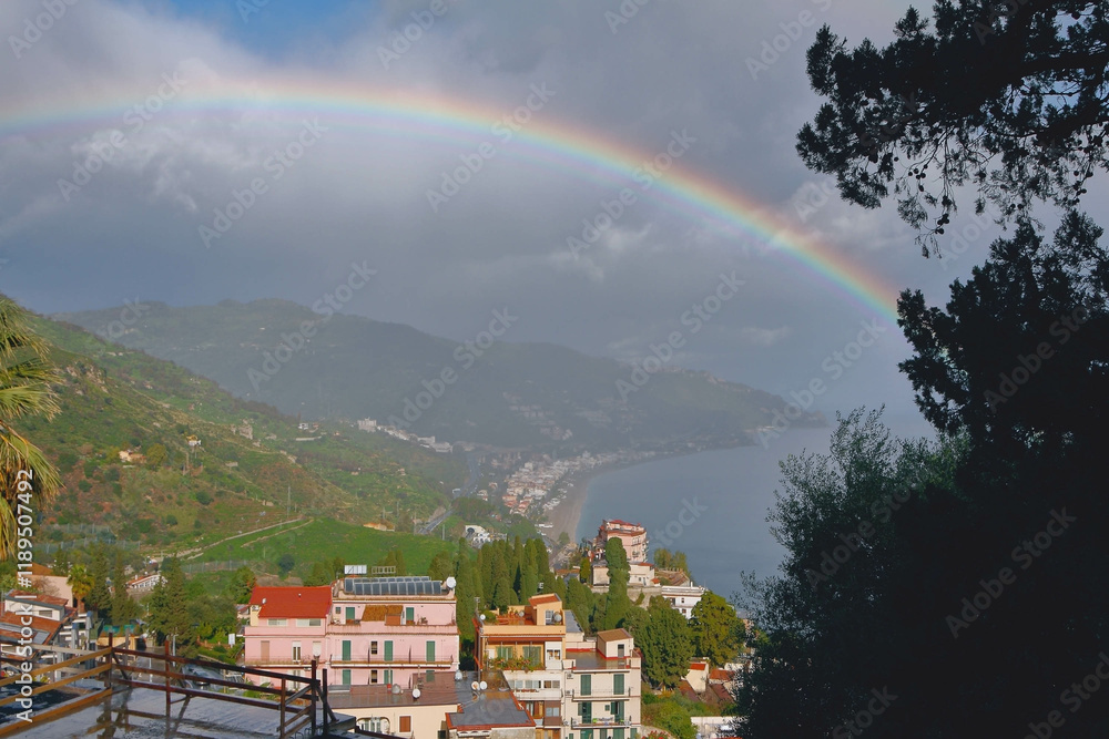 Rainbow over city on seashore. Taormina, Messina, Sicily, Italy